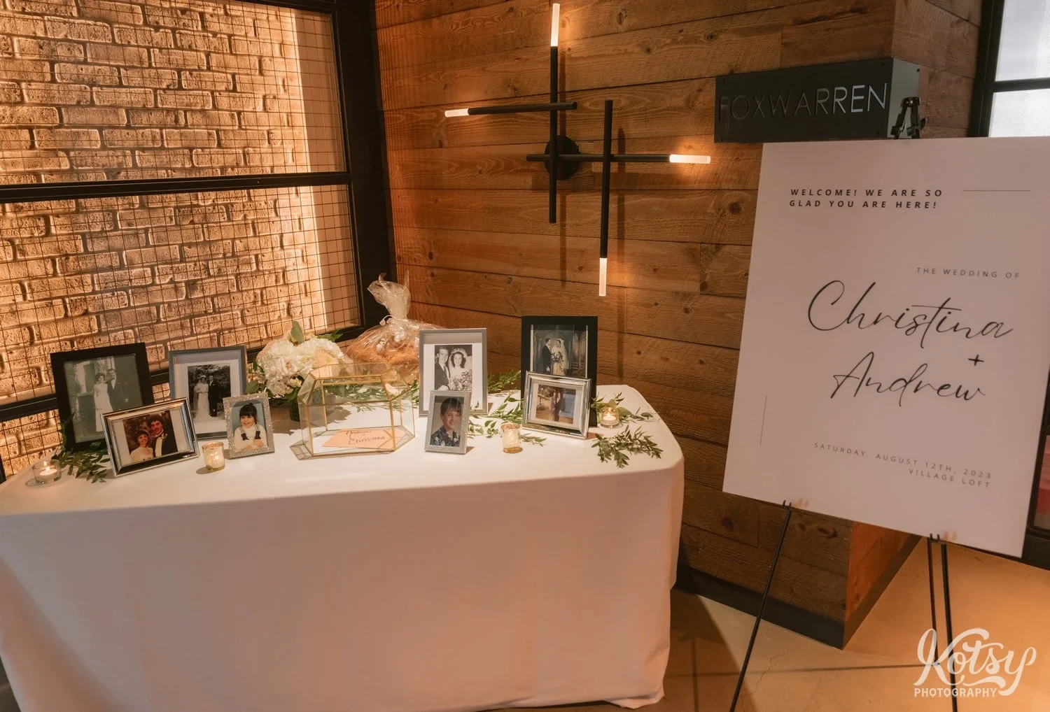 A sign reading "the wedding of Christina & Andrew" is seen next to a table of photos of the bride and groom.