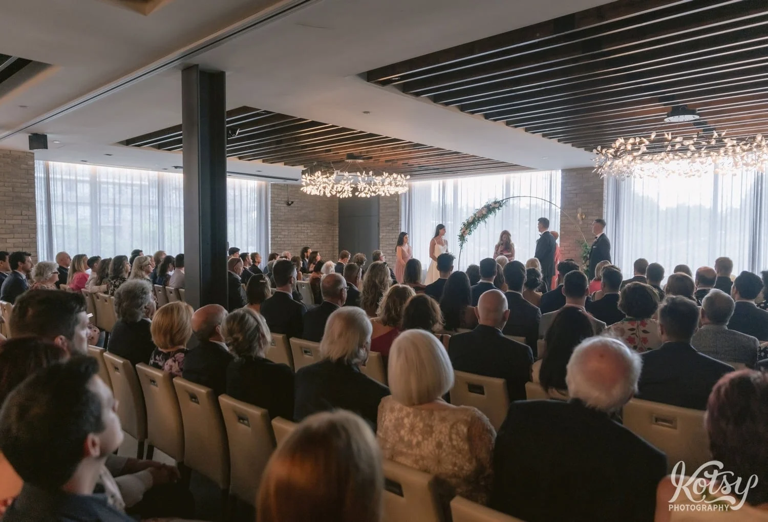 A wide shot of a wedding ceremony from the back of a room at Village Loft in Toronto, Canada