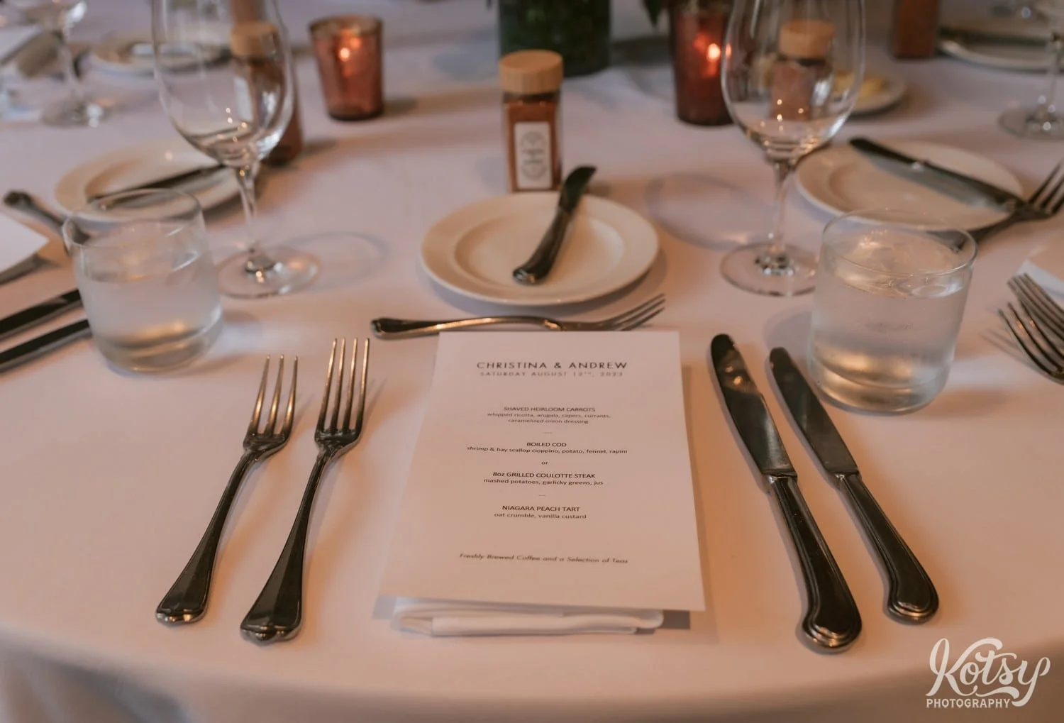 A menu for a 4 course meal is shown on a place setting at a Village Loft wedding reception in Toronto, Canada