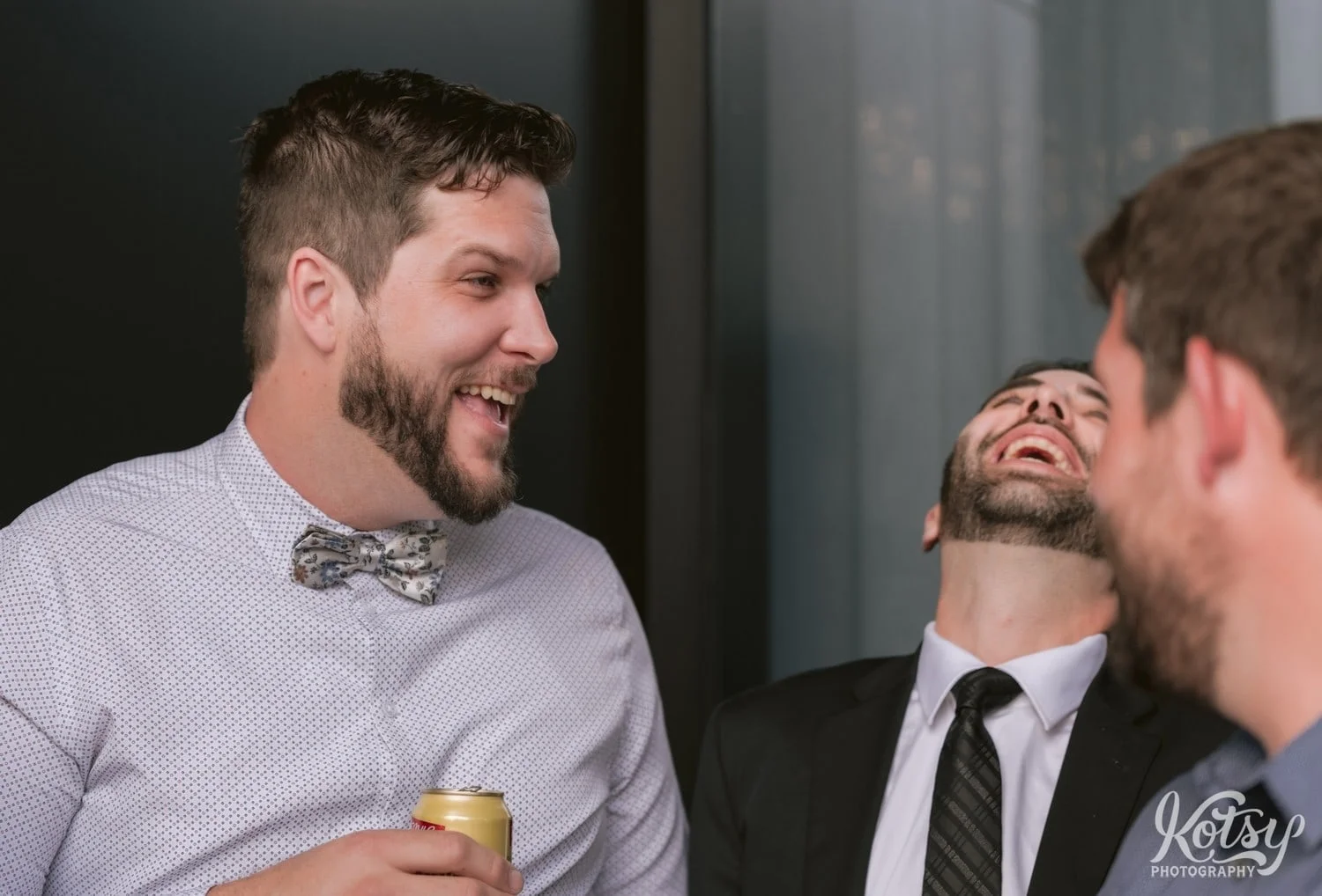 A man lets out a big laugh while head tilted back during a Village Loft wedding reception in Toronto, Canada
