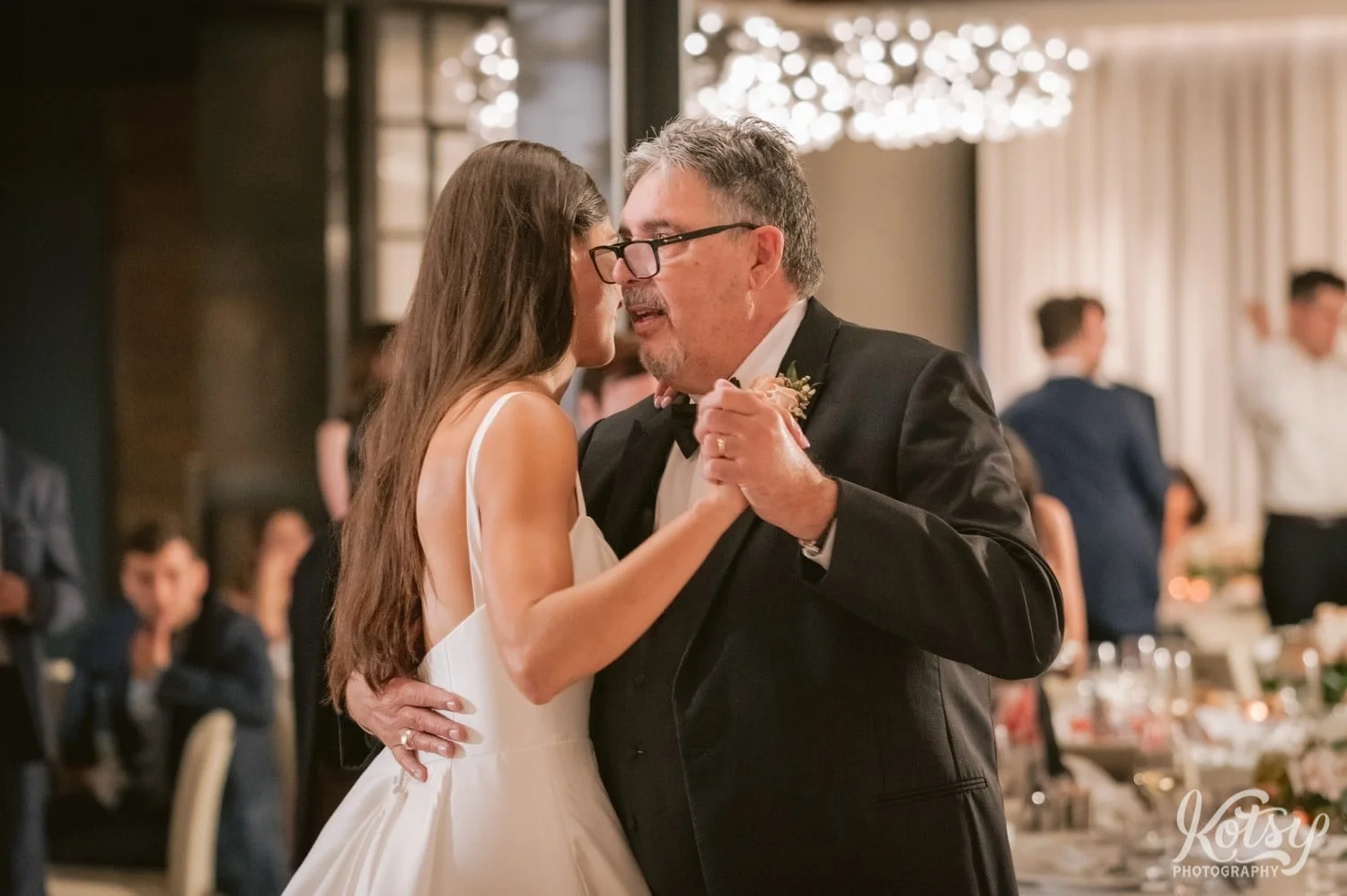 An elderly man dances with his daughter during her Village Loft wedding reception in Toronto, Canada