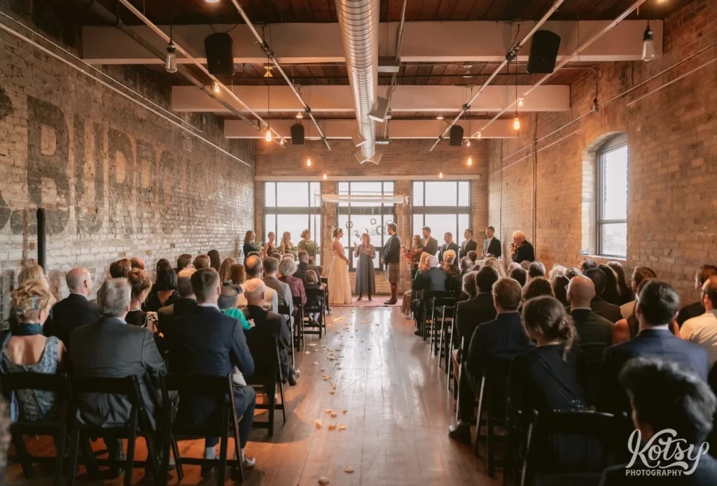 Shot from the back of a room during a Burroughes Building wedding ceremony in Toronto, Canada