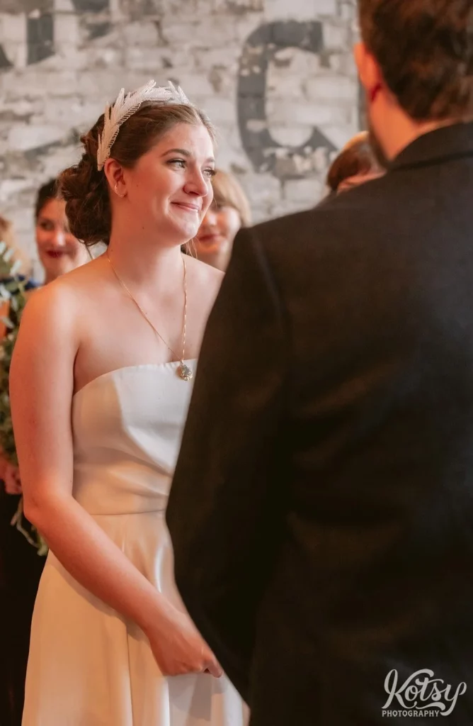 Close up of a bride in white wedding gown and White Sierra smiling to the officient during her Burroughes Building wedding ceremony in Toronto, Canada